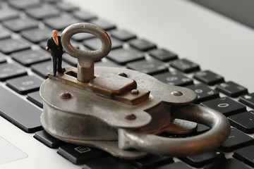 Internet security concept-miniature businessman stand on old key