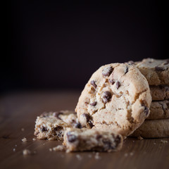 Stack of chocolate chip cookies on wooden table. Shallow DOF. Fo