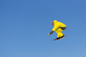 Fototapeta na wymiar Snowboarder jumps in Snow Park