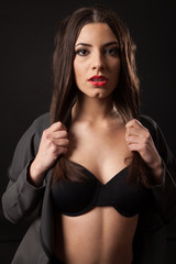 Fototapeta na wymiar Sexy brunette woman with retro black lingerie. Black background.