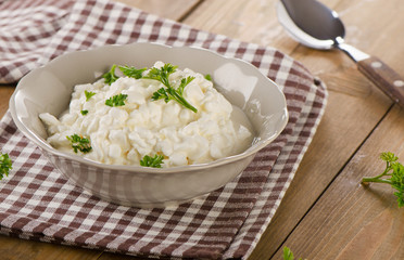 Fresh Cottage cheese with fresh herbs on  wooden table