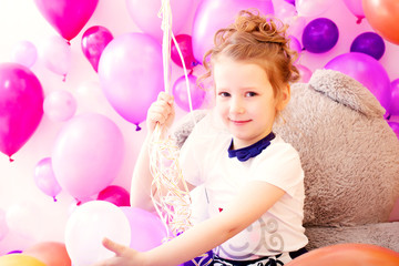 Fototapeta na wymiar Portrait of smiling girl on balloons background