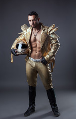 Studio shot of hot muscular man in golden costume