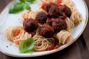 Close-up of spaghetti with meatballs and fresh green basil