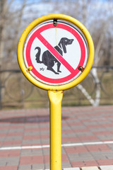 A sign in a park for no poop with the icon of a dog pooping