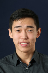 Young Asian man smiling and looking at camera - obrazy, fototapety, plakaty