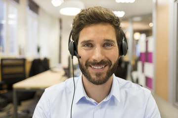 Cheerful Businessman in the office on video conference, headset, - obrazy, fototapety, plakaty