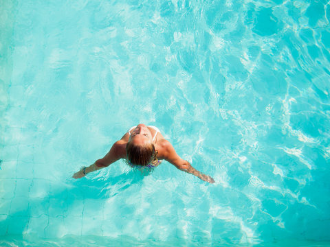 A girl is relaxing in a swimming pool