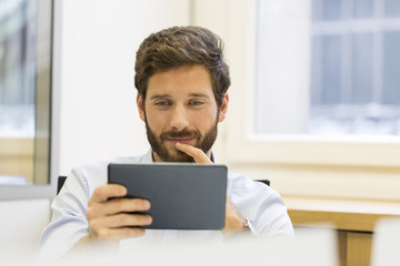 One cheerful man holding digital tablet in office