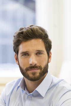 Portrait of handsome bearded man in office. looking at camera