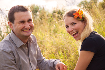 A couple having fun outdoors. Girl has an orchidea.