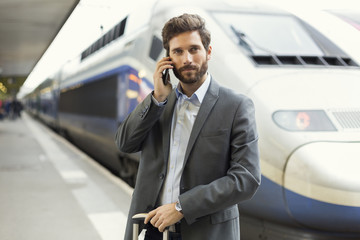 Man on the cell phone. Platform station. Train on background