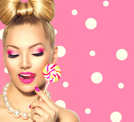 Beauty fashion model girl eating colorful lollipop