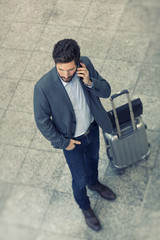 Casual business man on cell phone in hall airport. Top View