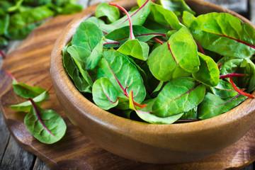 Fresh chard leaves in wooden bowl