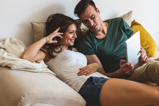 Young couple using digital tablet  at home.