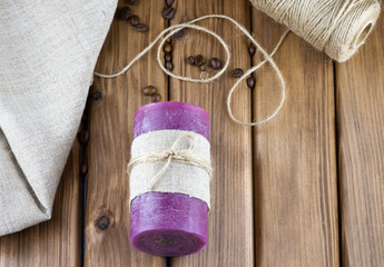 Top view of purple candle decorated with sackcloth and twine