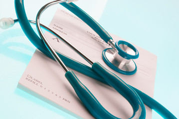 Empty medical prescription with a stethoscope on blue reflective background