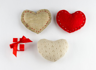 Small red gift box and different soft hearts on white background