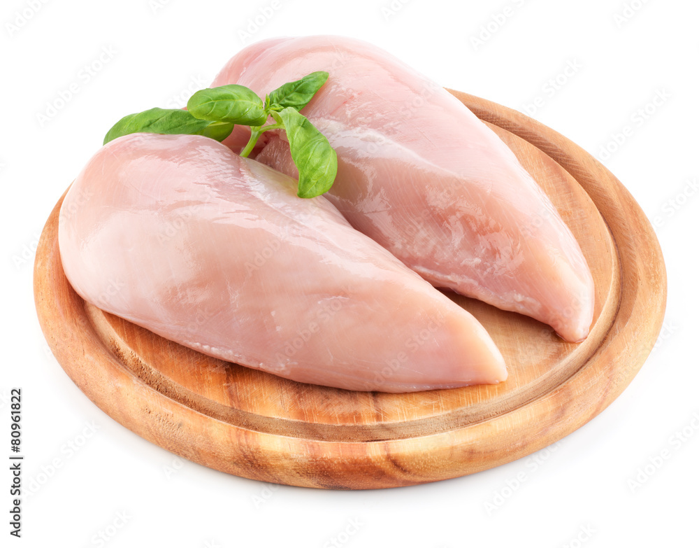 Wall mural raw chicken fillets on wooden board isolated on white