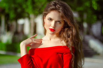 Beautiful young girl Outdoor portrait. Fashion brunette in red d