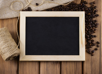 Blank blackboard with roasted coffee beans, twine and sackcloth