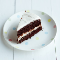 Chocolate cake in white plate on wooden table