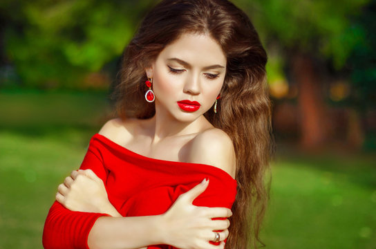 Attractive beautiful girl with fashion earring wearing in red dr