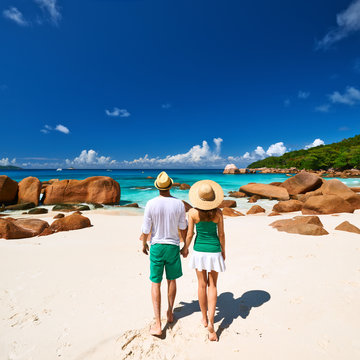 Couple in green walking on a beach at Seychelles