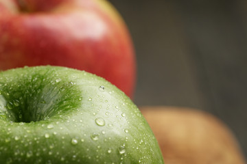 two ripe apples on olive cutting board
