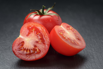 ripe washed tomatoes on slate background