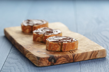 baguette slices with chocolate hazelnut spread on olive board