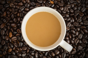 Hot latte coffee cup on coffee beans background.