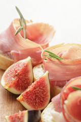 canapes with jamon and figs on wooden board