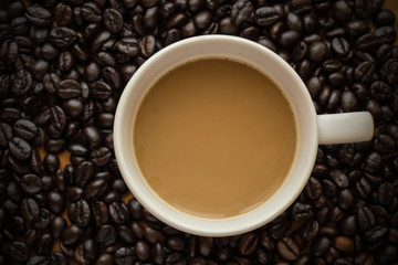 Hot latte coffee cup on coffee beans background.