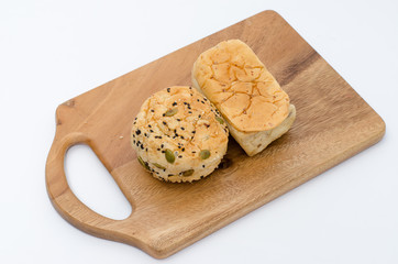 Bread slices on wood cutting board on white background