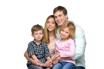 Young family of four posing and looking at camera