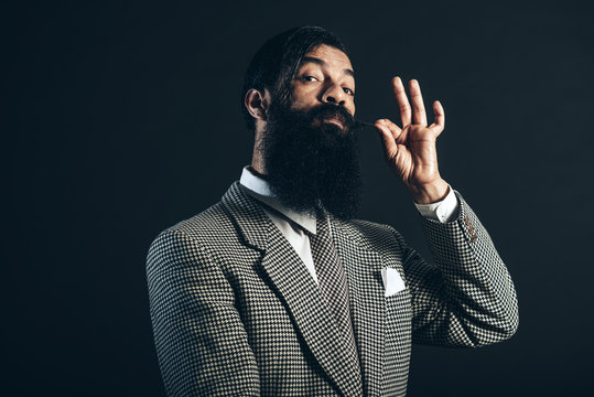 Man Holding his Mustache While Looking at Camera