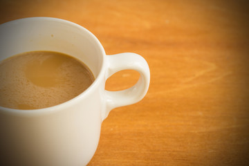 Hot latte coffee cup on wood background and texture.