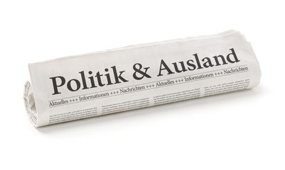 Zeitungsrolle mit der Überschrift Politik und Ausland