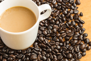 Hot latte coffee cup on coffee beans background.