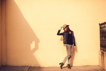 cheerful girl posing on wall background on a sunny day