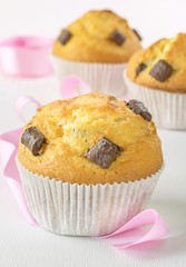 Chocolate chip muffins with pink ribbon deco on white background