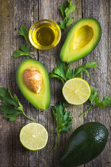 food background with fresh organic avocado, lime, parsley and ol