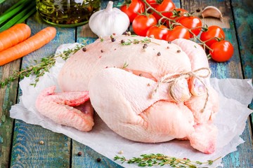 organic raw chicken with thyme, tomatoes, carrots