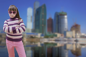 Teenage girl in pink wears sunglasses with modern city in