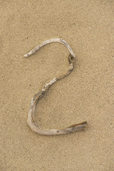 Fototapeta na wymiar Zahl 2 aus Treibholz auf Sand