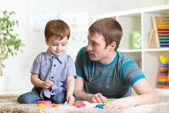 father and child boy play together indoor at home