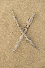 Alphabet Buchstabe X aus Treibholz auf Sand