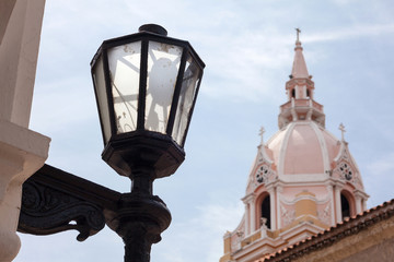 Fototapeta na wymiar Antiguo farol en la ciudad amurallada de Cartagena de Indias con la famosa Catedral de Santa Catalina de Alejandría al fondo en Colombia